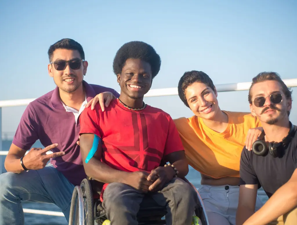 Friends outdoors together, one of them a wheelchair user