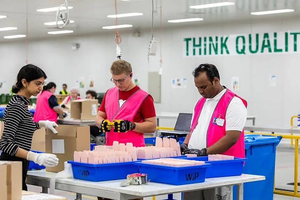 Supported employees packing products together on a production line