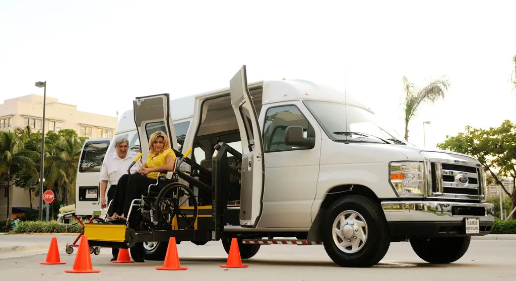 An accessible van lift lowering a wheelchair user to the kerb